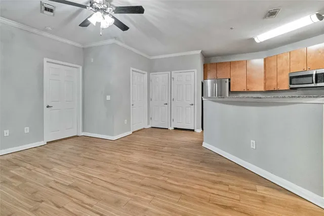 a view of kitchen with stainless steel appliances refrigerator stove and wooden cabinets