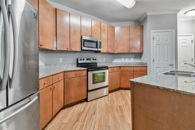 a kitchen with granite countertop a sink stainless steel appliances and cabinets