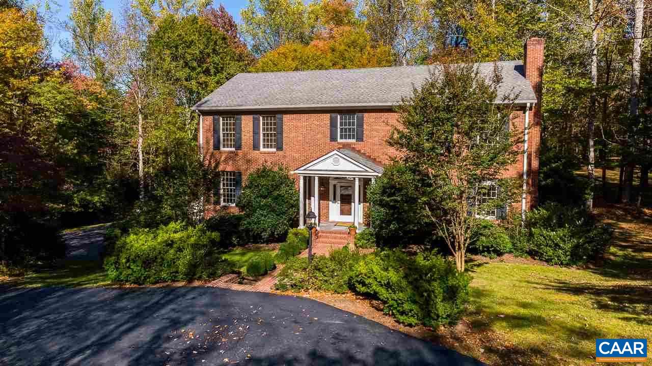 a front view of a house with a yard and shrubs