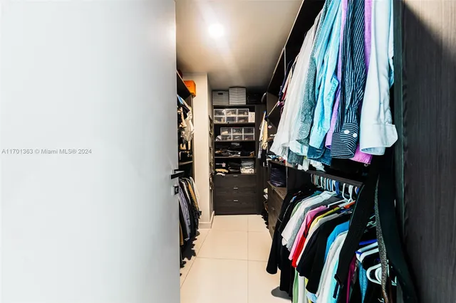 a view of walk in closet with clothes and shoes