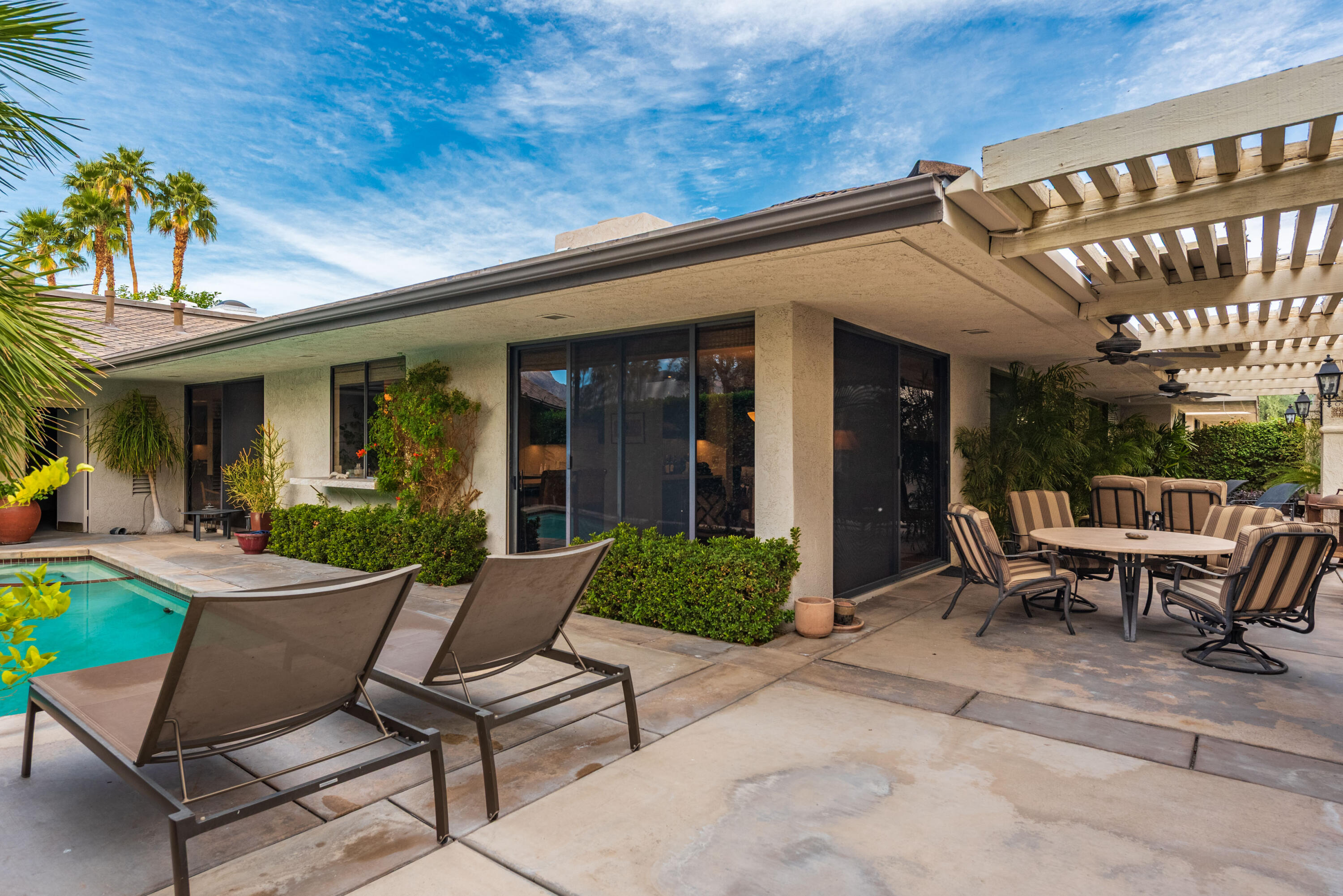 3 Cornell Drive Rancho Mirage, CA 92270 - Photo 42 of 46 a view of a patio with a table and chairs
