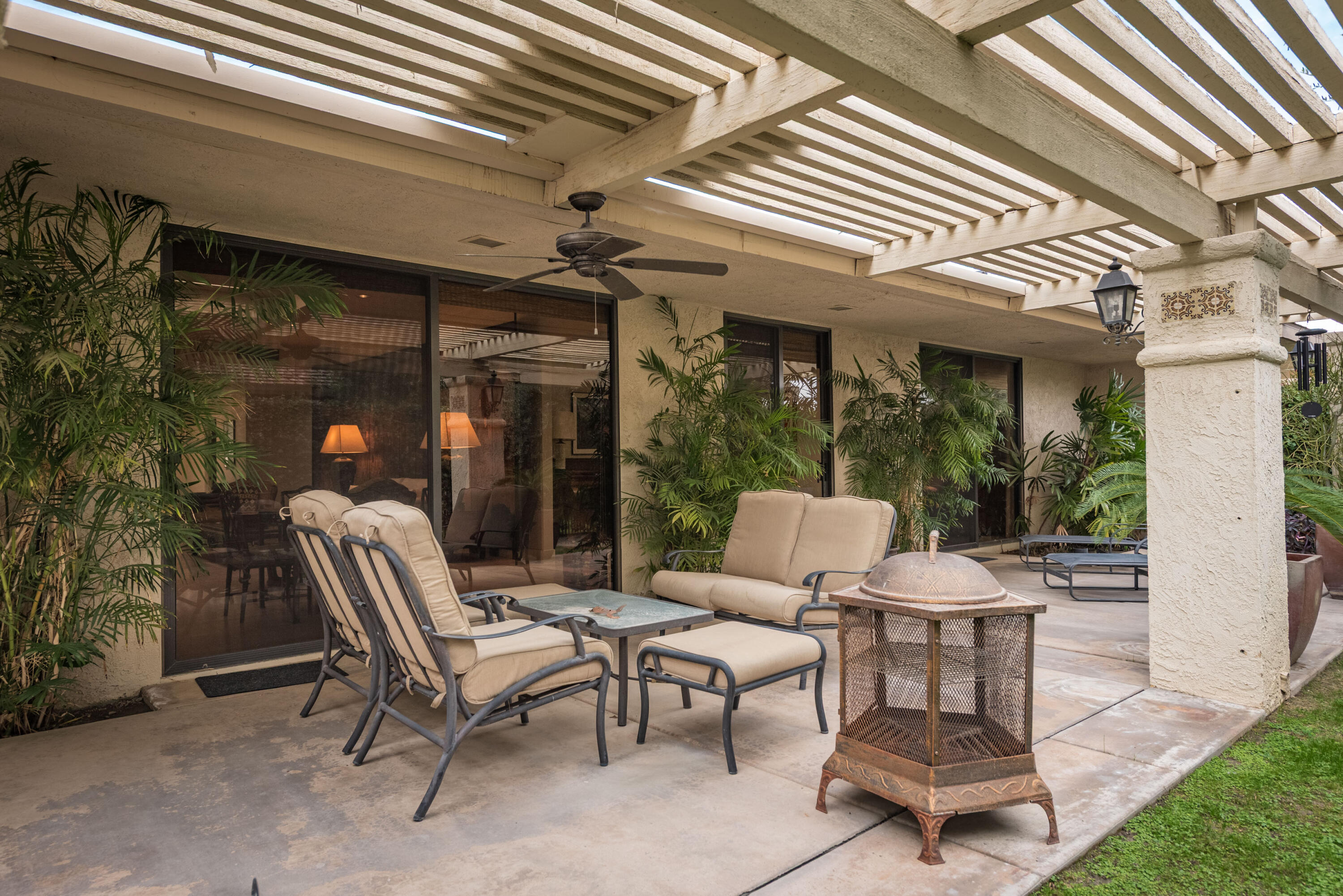 3 Cornell Drive Rancho Mirage, CA 92270 - Photo 44 of 46 a view of a patio with a dining table and chairs under an umbrella