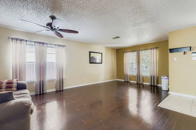 a view of a kitchen with kitchen island a large counter top space a sink stainless steel appliances and cabinets