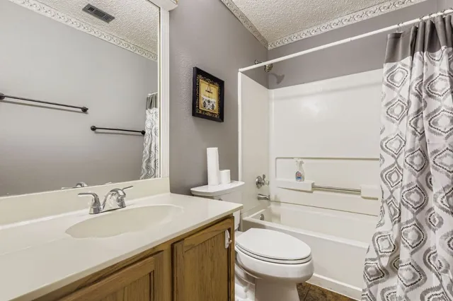 a bathroom with a granite countertop sink toilet a mirror and shower