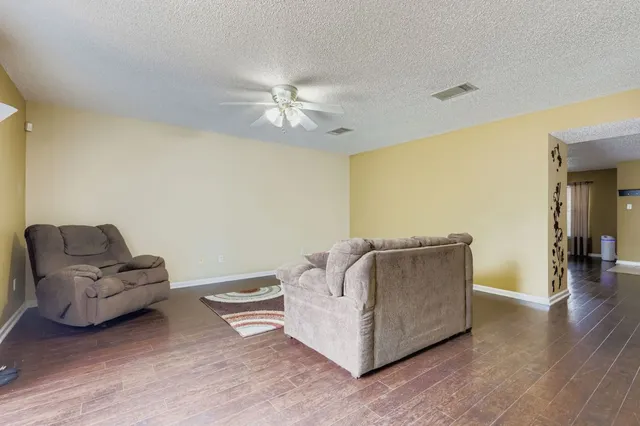 a living room with furniture and a ceiling fan