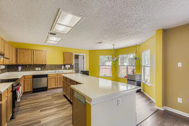 a large kitchen with a lot of counter space and wooden floor