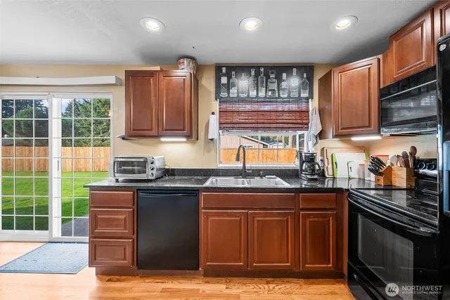 a kitchen with stainless steel appliances granite countertop wooden cabinets stove top oven and sink