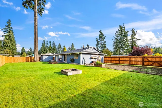 a view of a house with backyard and a tree