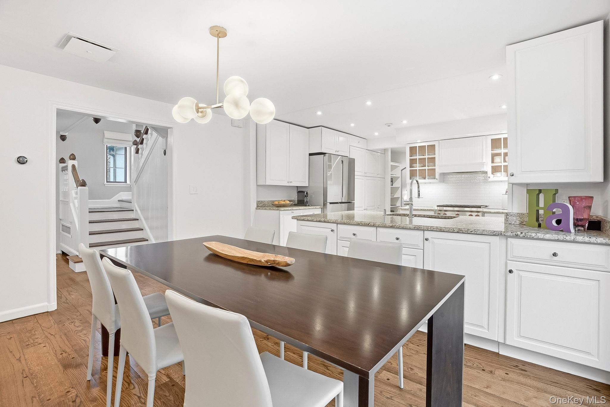 22 Taunton Road Scarsdale, NY 10583 - Photo 12 of 41 a kitchen with stainless steel appliances granite countertop a dining table chairs and a refrigerator