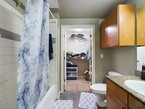 a bathroom with a granite countertop toilet a sink and a shower