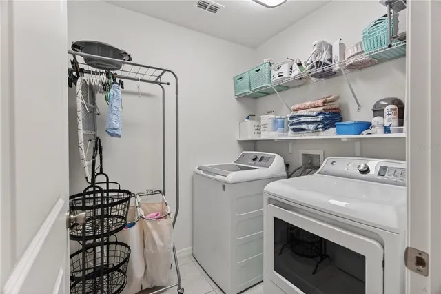 a utility room with dryer washer and other items