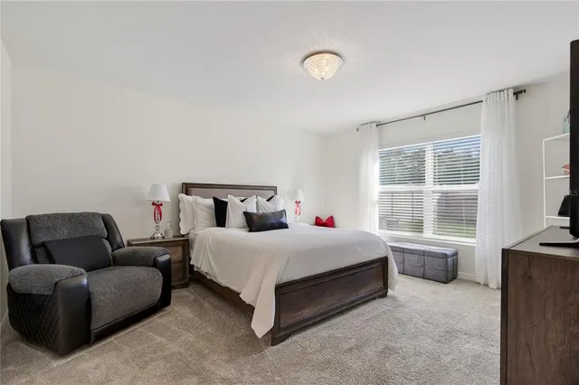 a bedroom with a bed couch and window