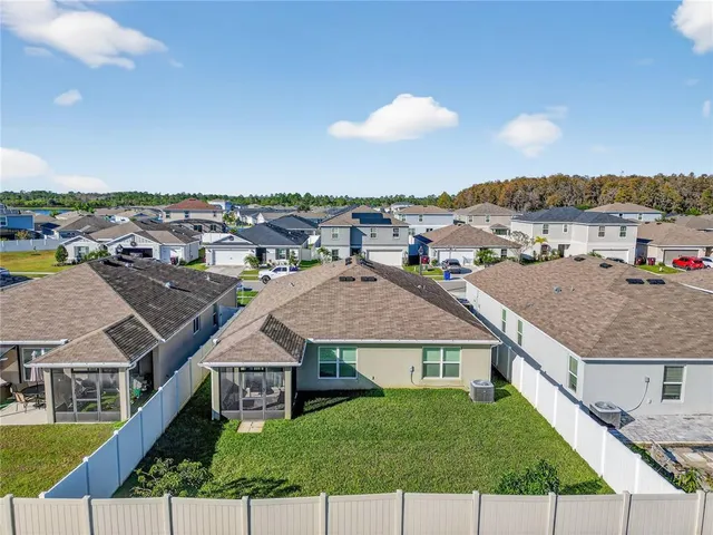 an aerial view of residential houses with outdoor space and swimming pool