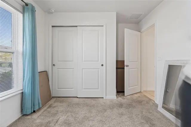 an empty room with windows and closet