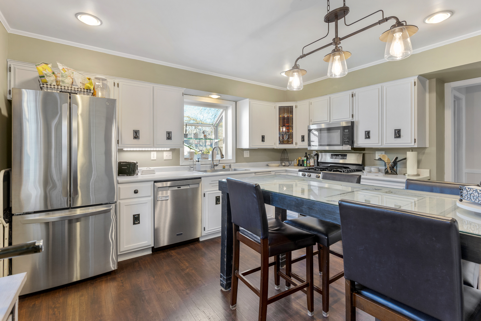 32 Jayne Street Algonquin, IL 60102 - Photo 3 of 22 a kitchen with kitchen island granite countertop a refrigerator a stove a sink and white cabinets with wooden floor