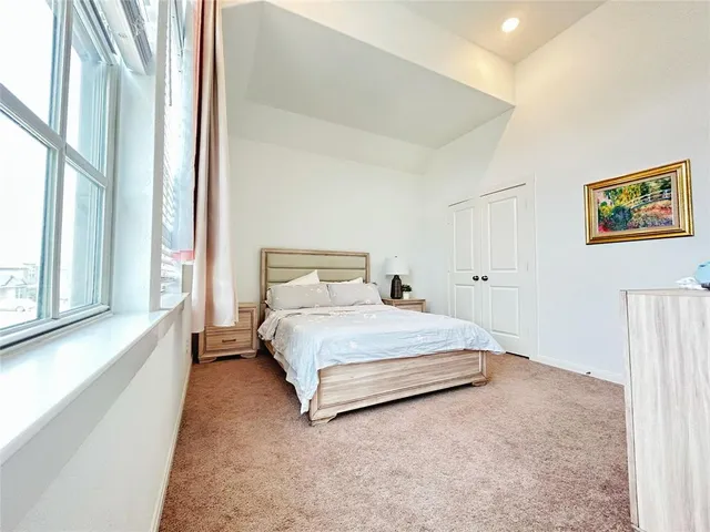 a bedroom with a bed and a large window