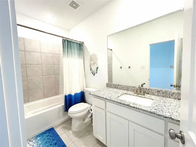a bathroom with a granite countertop sink a toilet and shower