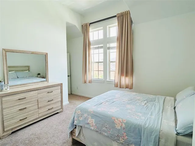 a spacious bedroom with a bed and a dresser