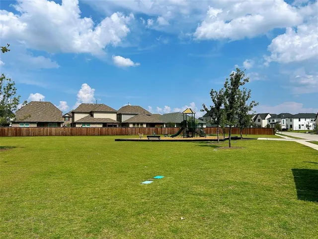 a front view of a house with a garden and lake