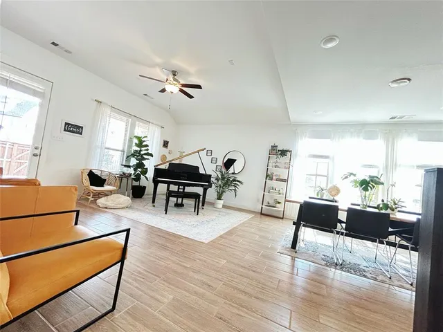 a living room with furniture a dining table and wooden floor