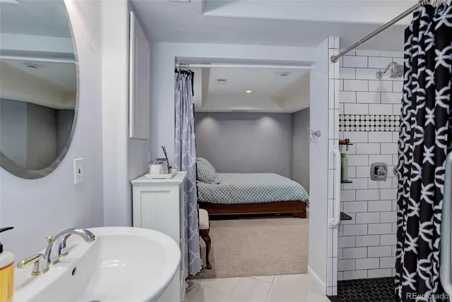 a bathroom with a granite countertop sink a mirror and shower