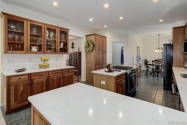 a kitchen with stainless steel appliances granite countertop a sink a stove and a refrigerator