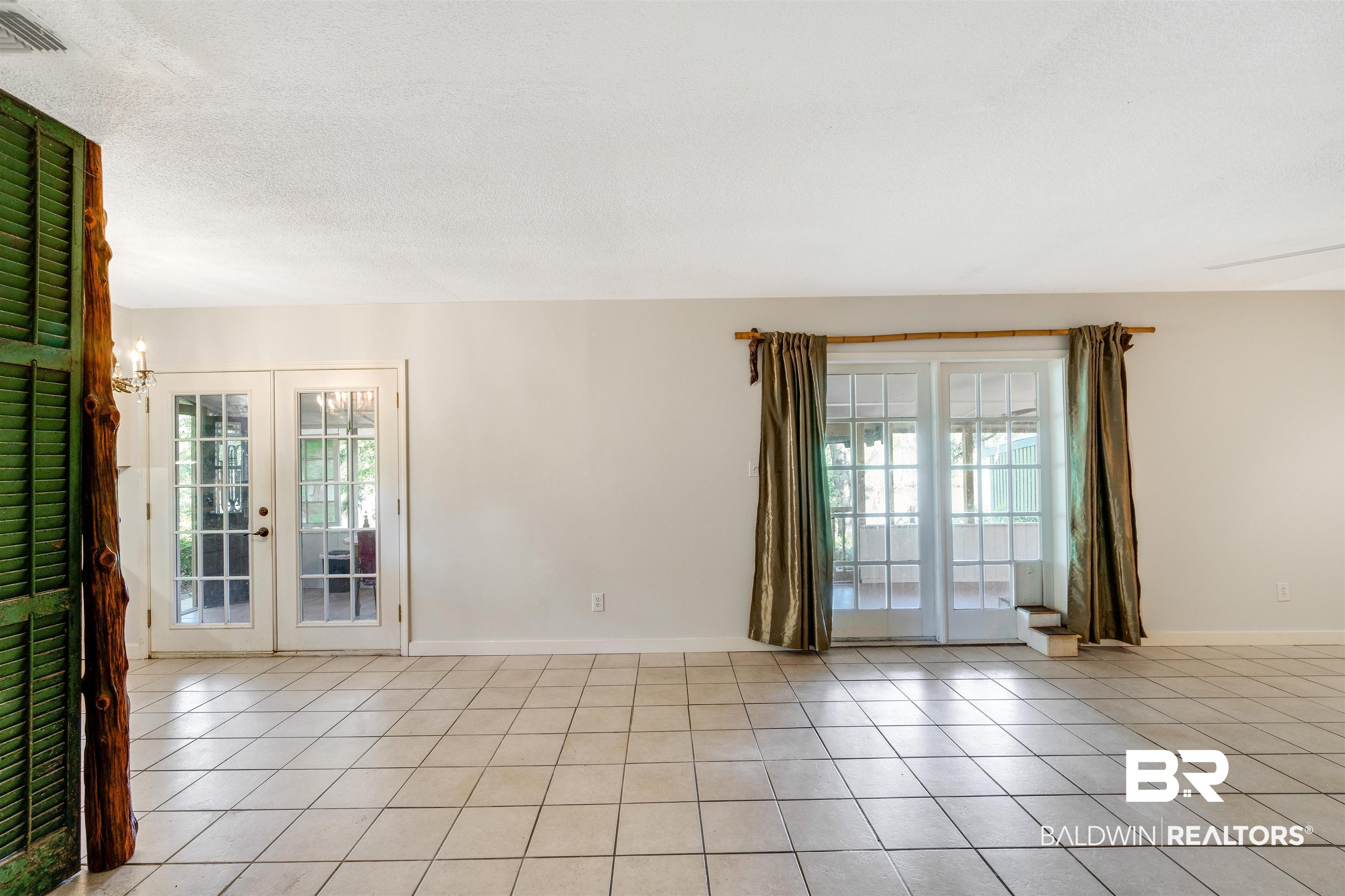34341 Lost River Road Seminole, AL 36574 - Photo 8 of 36 Empty room featuring light tile patterned flooring and french doors