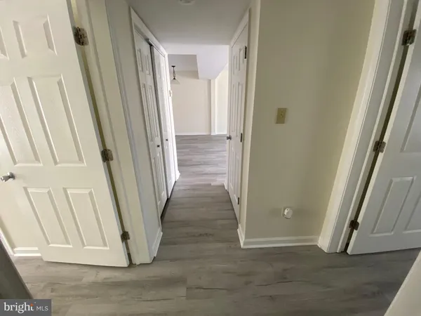 a view of a hallway with wooden floor and entryway