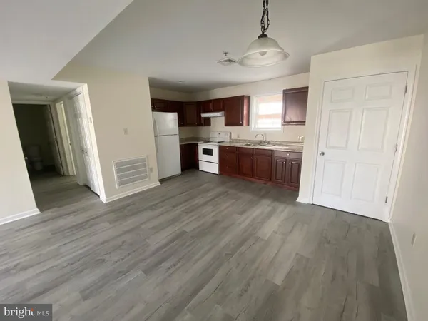 a large kitchen with a wooden floor and stainless steel appliances
