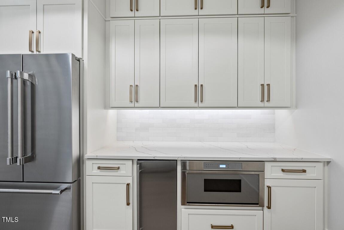 4139 Rockingham Drive Raleigh, NC 27609 - Photo 20 of 77 a kitchen with granite countertop white cabinets and refrigerator