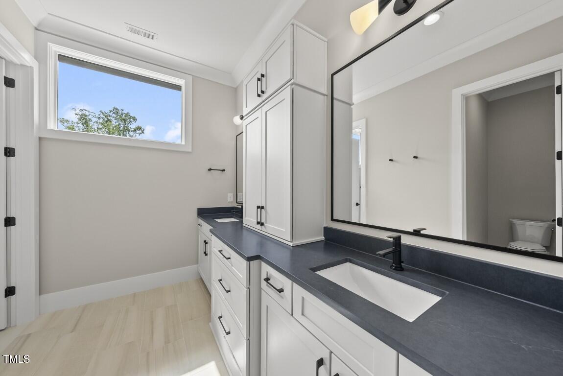 4139 Rockingham Drive Raleigh, NC 27609 - Photo 38 of 77 a bathroom with a sink and a mirror