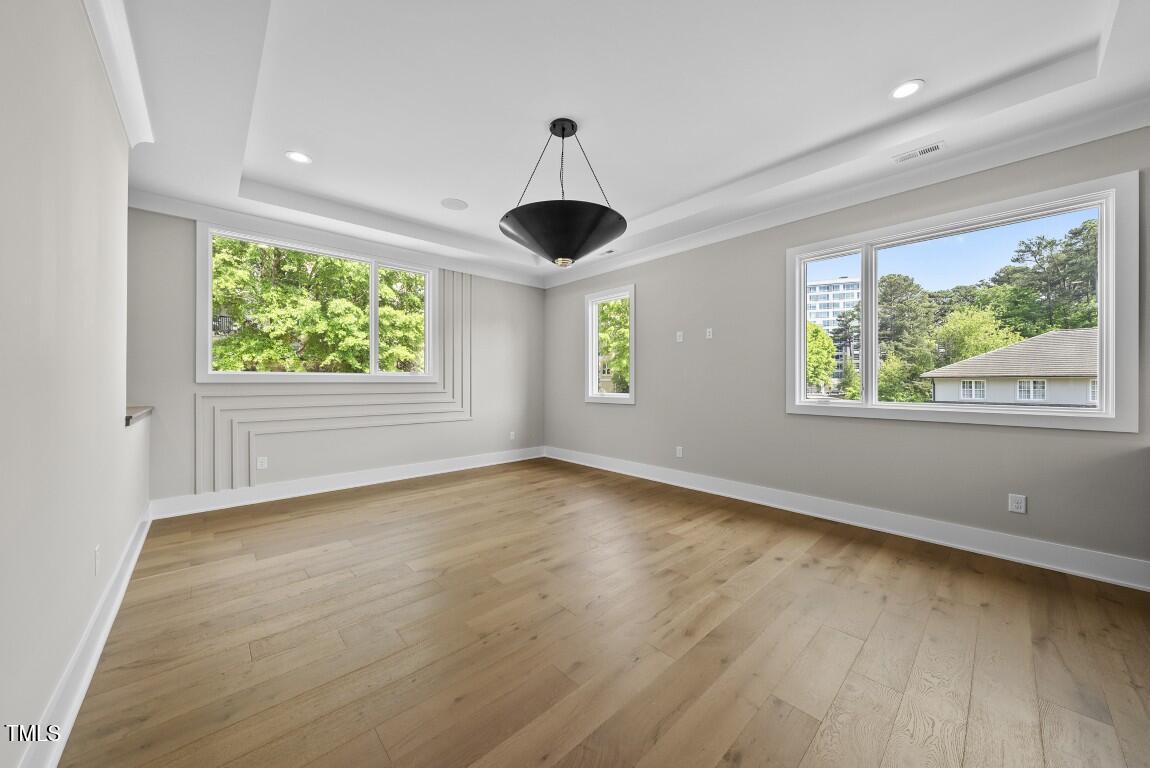 4139 Rockingham Drive Raleigh, NC 27609 - Photo 47 of 77 a view of an empty room with wooden floor and windows