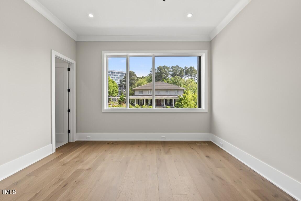 4139 Rockingham Drive Raleigh, NC 27609 - Photo 57 of 77 an empty room with wooden floor and windows