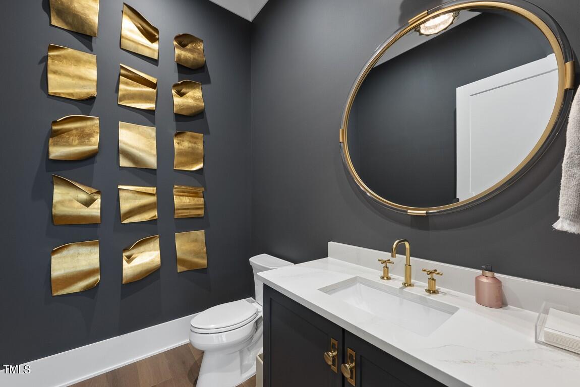 4139 Rockingham Drive Raleigh, NC 27609 - Photo 67 of 77 a bathroom with a toilet sink vanity and mirror