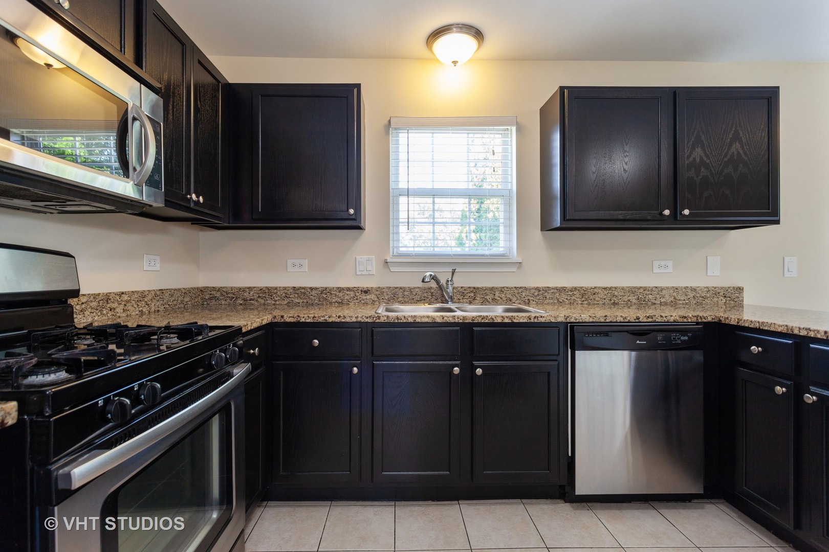 2068 Sutcliffe Drive Romeoville, IL 60446 - Photo 2 of 10 a kitchen with granite countertop stainless steel appliances a sink stove and microwave