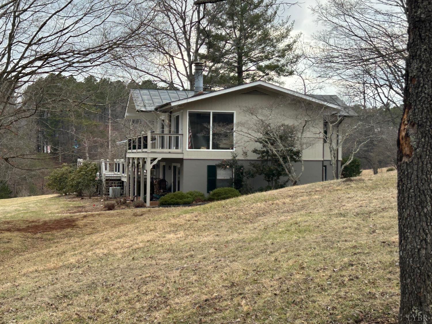 4775 Coffee Road Forest, VA 24551 - Photo 2 of 5 a house with trees in the background