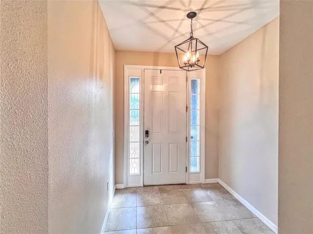 a view of a hallway with a chandelier and entryway