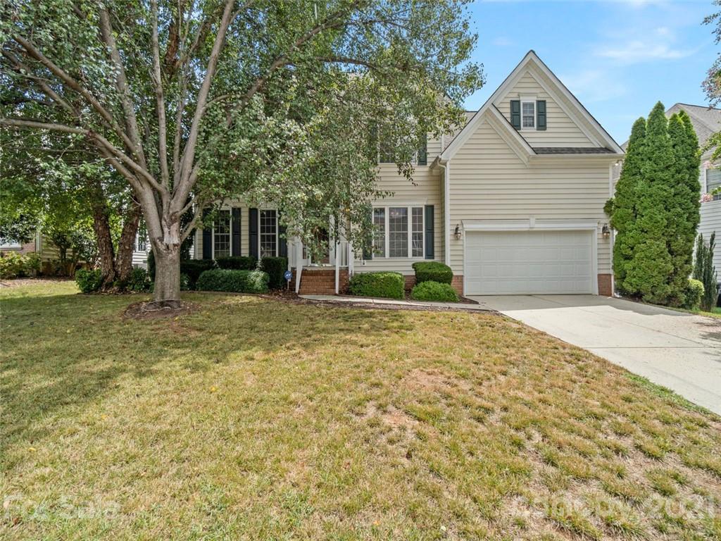a front view of house with yard and green space