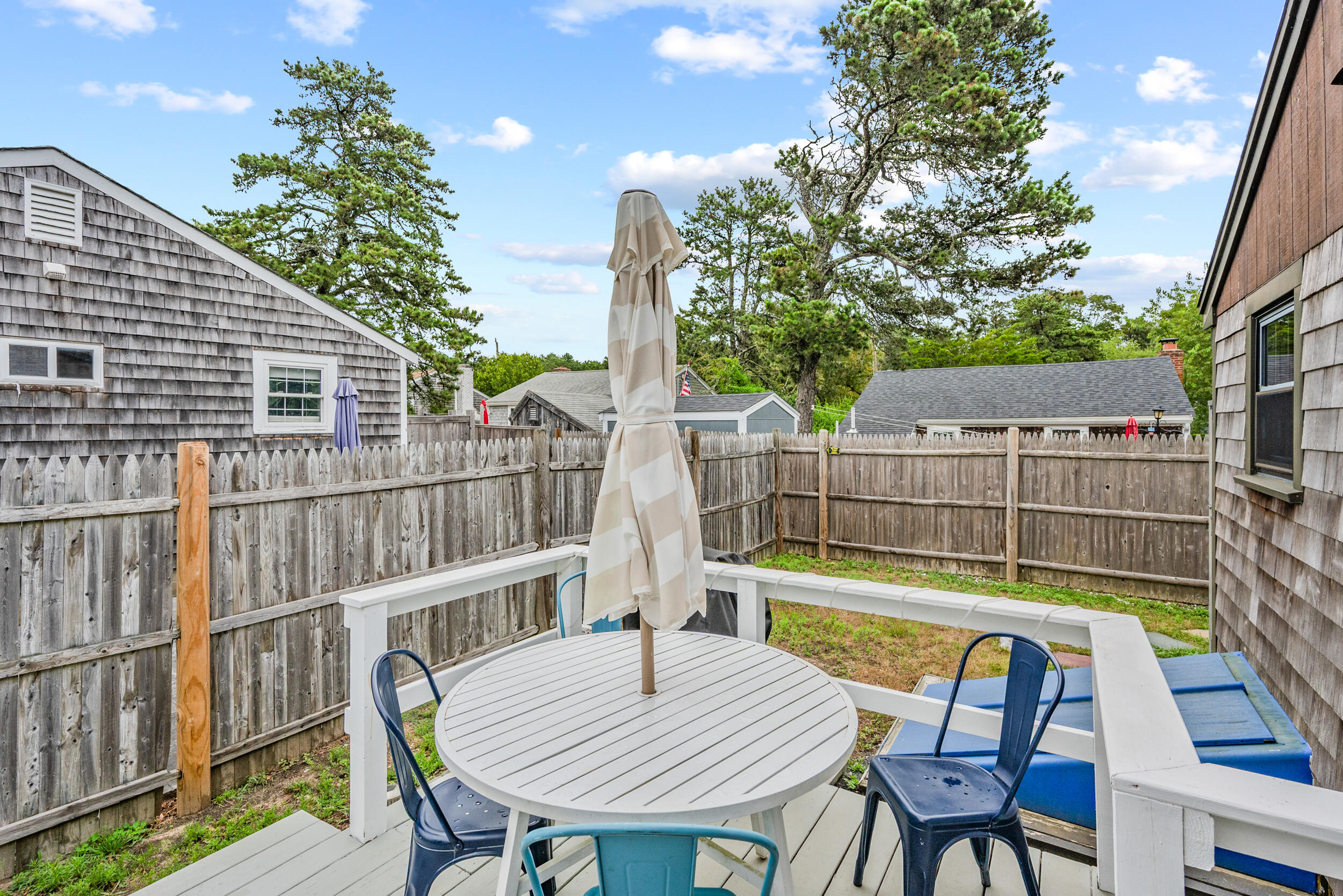 22 Wixon Road Dennis Port, MA 02639 - Photo 23 of 28 a view of a balcony with table and chairs and wooden fence