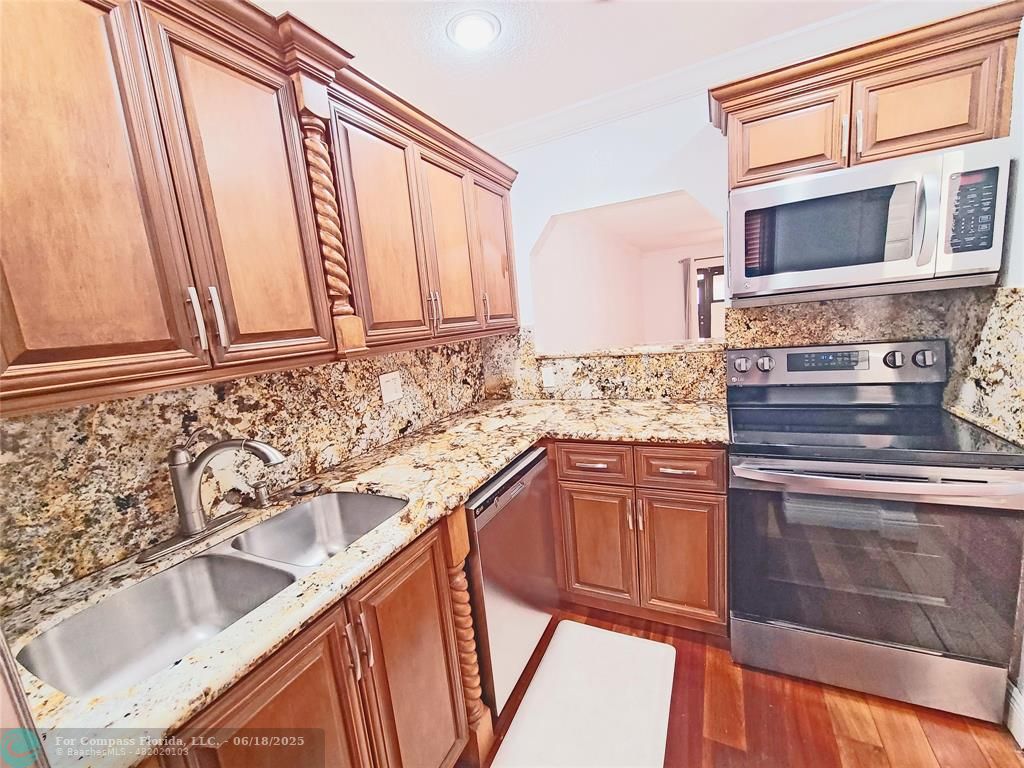 139 Sparrow Drive, Unit 4B Royal Palm Beach, FL 33411 - Photo 27 of 48 a kitchen with granite countertop a sink stove and microwave
