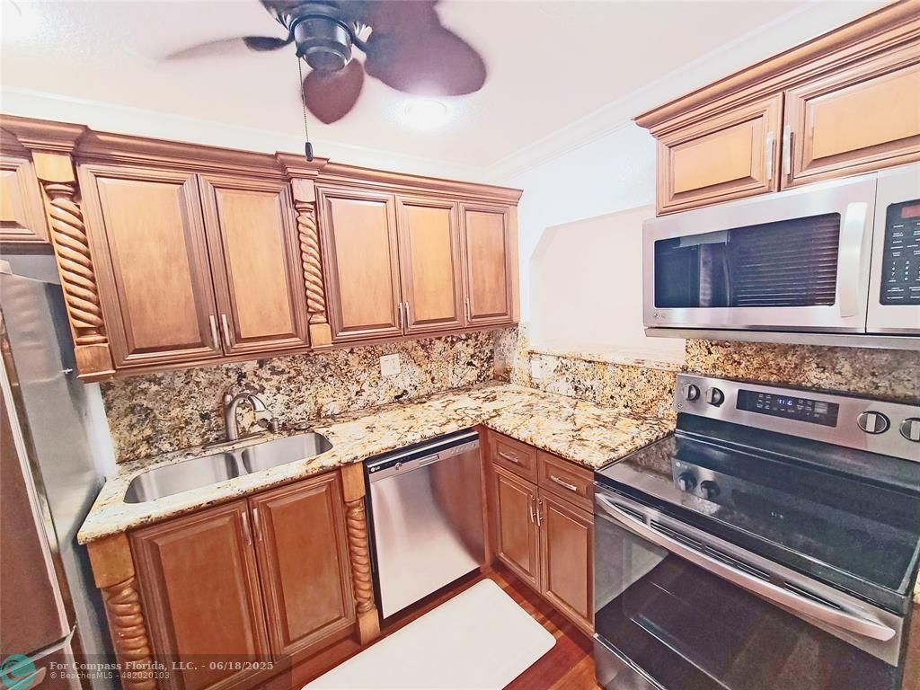 139 Sparrow Drive, Unit 4B Royal Palm Beach, FL 33411 - Photo 3 of 48 a kitchen with stainless steel appliances granite countertop a sink and a stove
