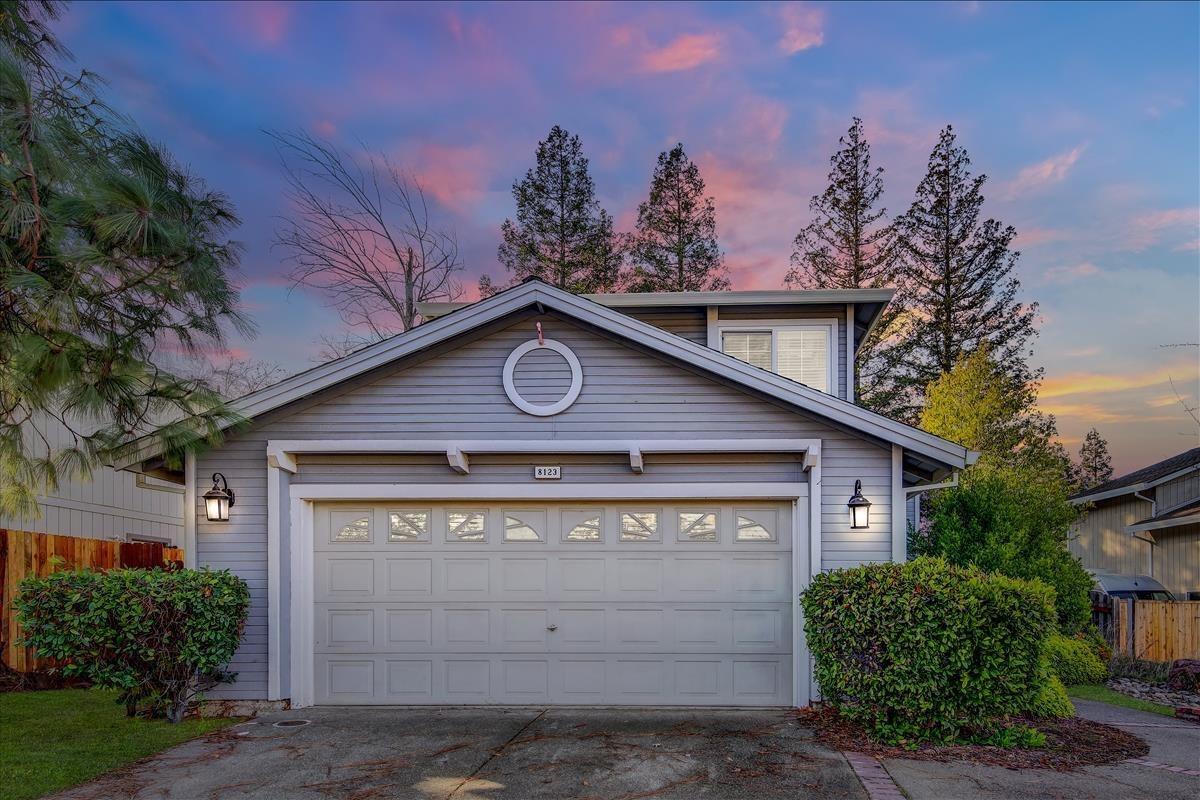 a front view of a house with yard and trees