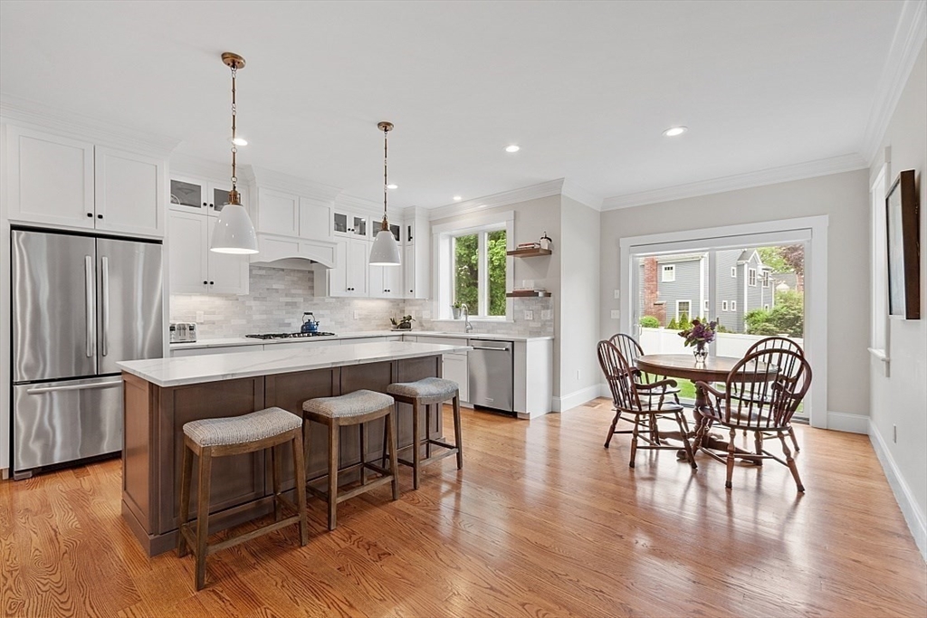 63 Thornton Road Needham, MA 02492 - Photo 8 of 41 a kitchen with stainless steel appliances granite countertop a dining table chairs stove refrigerator and cabinets