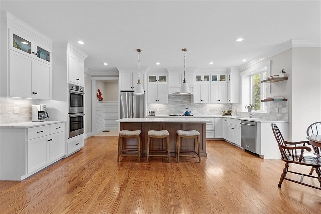 63 Thornton Road Needham, MA 02492 - Photo 9 of 41 a kitchen with a table chairs wooden cabinets and white appliances