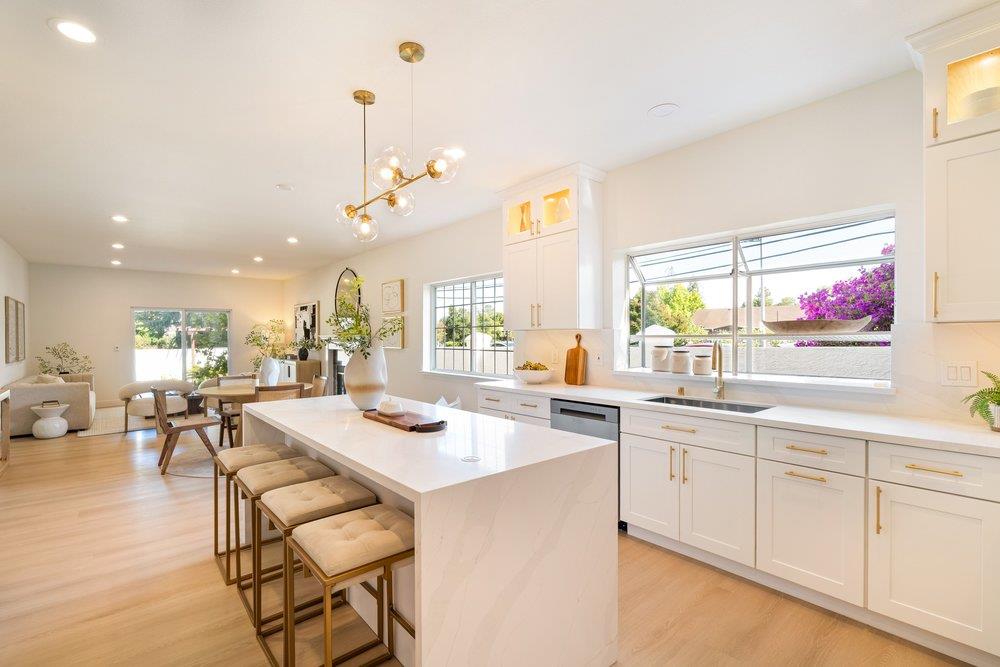 10496 South Stelling Road Cupertino, CA 95014 - Photo 17 of 54 a room with stainless steel appliances kitchen island granite countertop a stove a sink a dining table and chairs with wooden floor