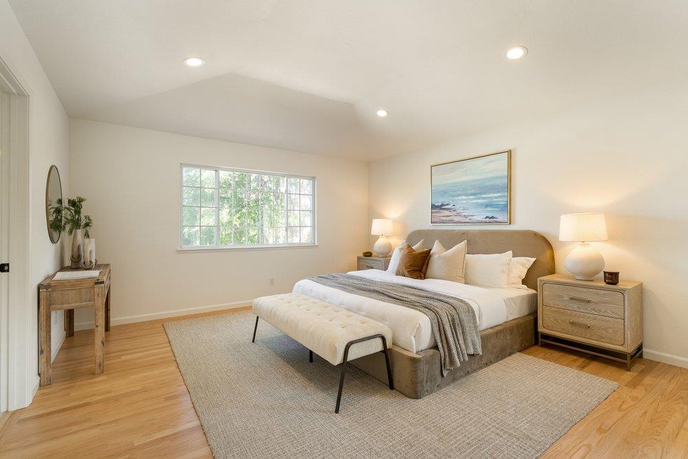 10496 South Stelling Road Cupertino, CA 95014 - Photo 25 of 54 a bedroom with a large bed and a chandelier