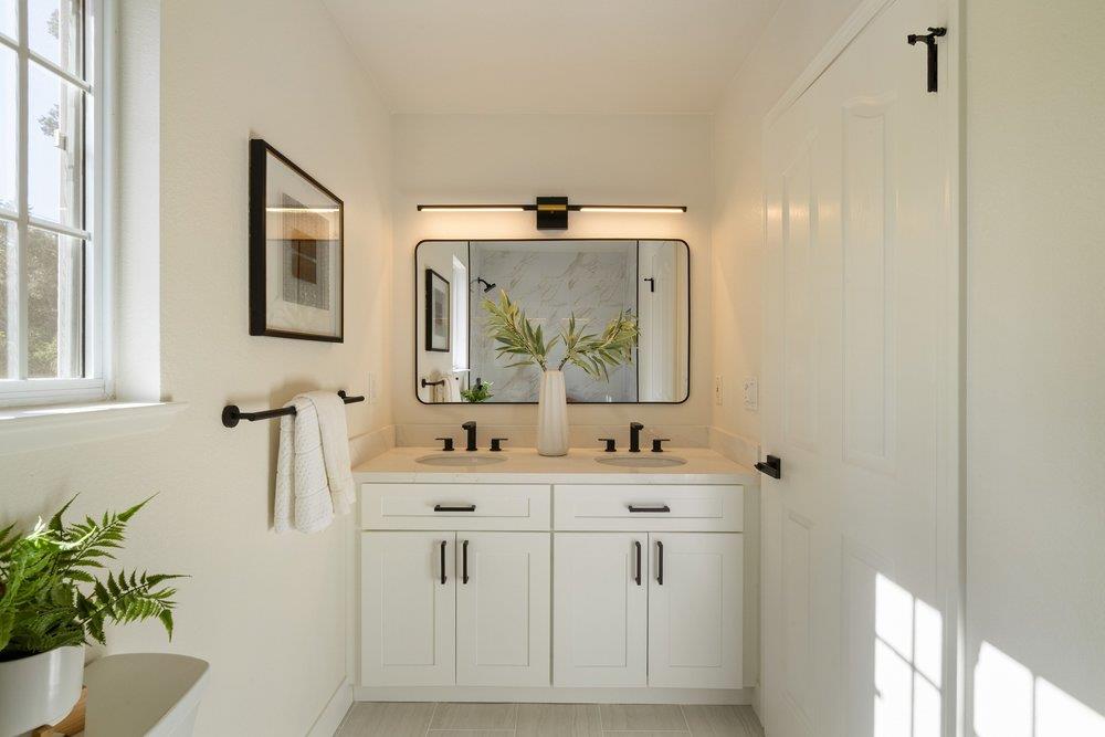10496 South Stelling Road Cupertino, CA 95014 - Photo 37 of 54 a bathroom with a double vanity sink a mirror and a bathtub