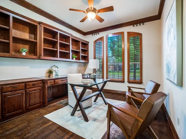 a view of a workspace with furniture and a window