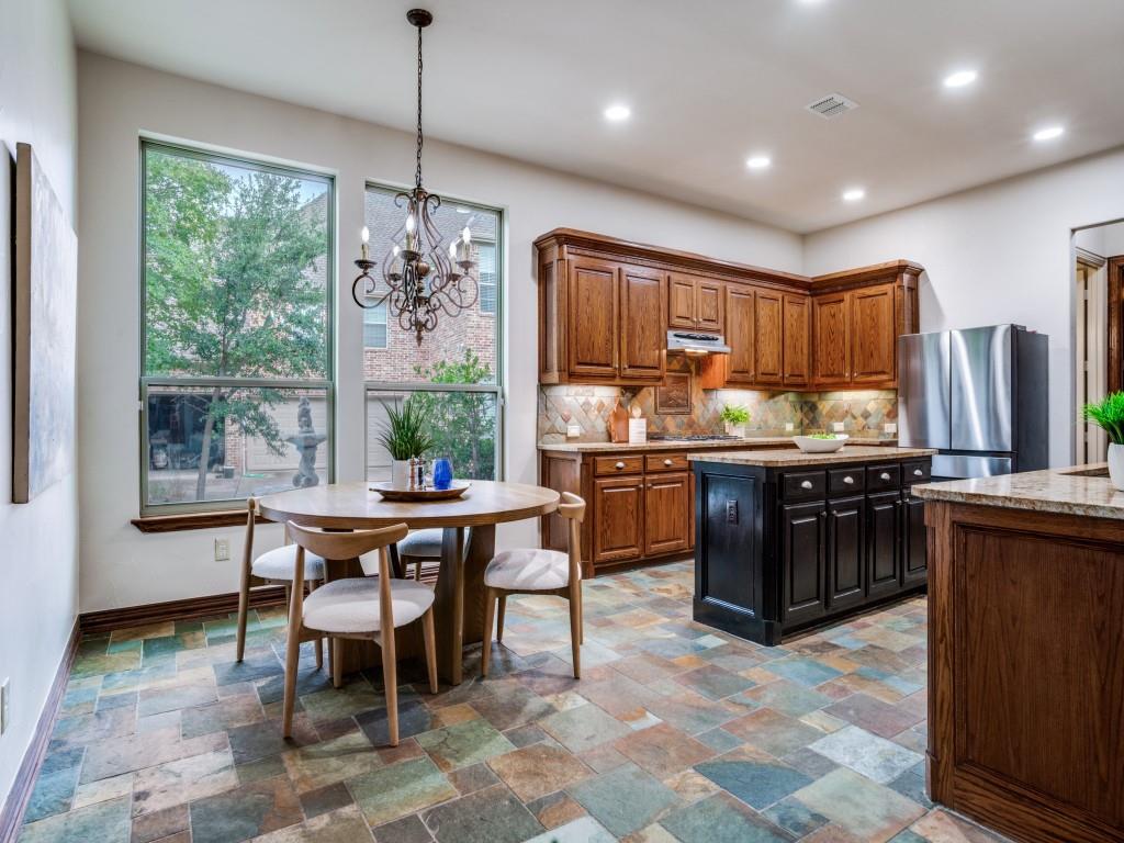 1908 Bordeaux Court Allen, TX 75002 - Photo 9 of 28 a kitchen with kitchen island a large counter space dining table and stainless steel appliances