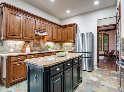 a kitchen with stainless steel appliances granite countertop a stove a refrigerator and a sink